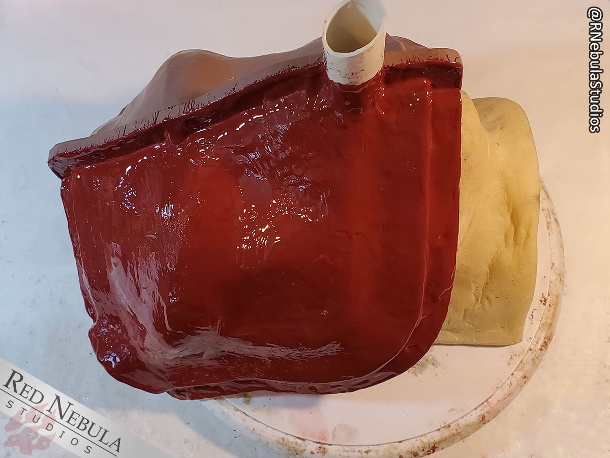 The first layer of red Epoxacoat over the clay around the owl mask.