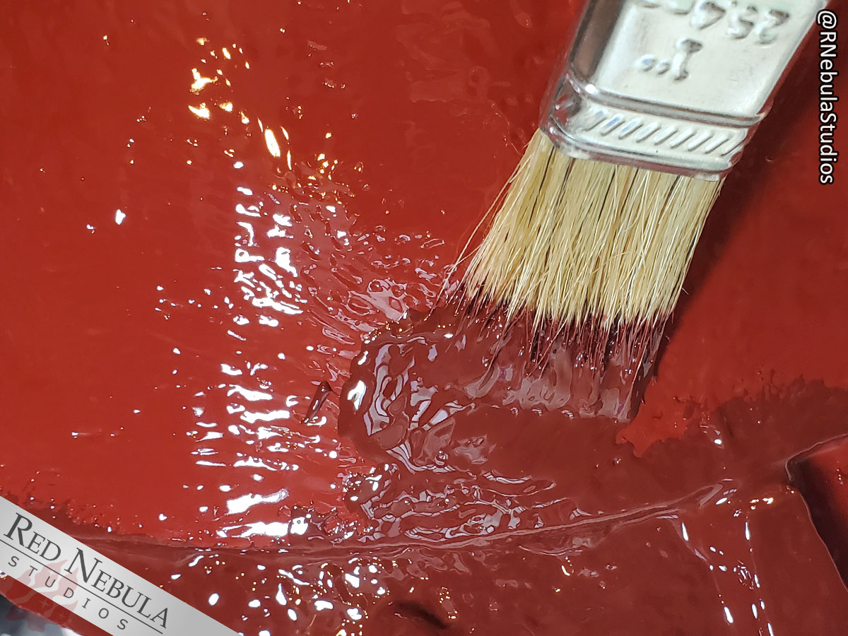 The second layer of red Epoxacoat, colored slightly darker, being applied with a chip brush.