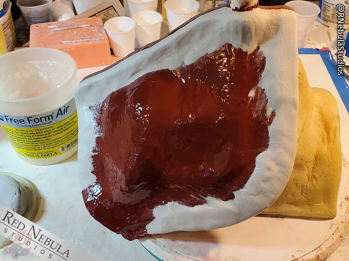 A layer of FreeForm Air epoxy putty in the process of being applied over the Epoxacoat mold shell on the owl mask.
