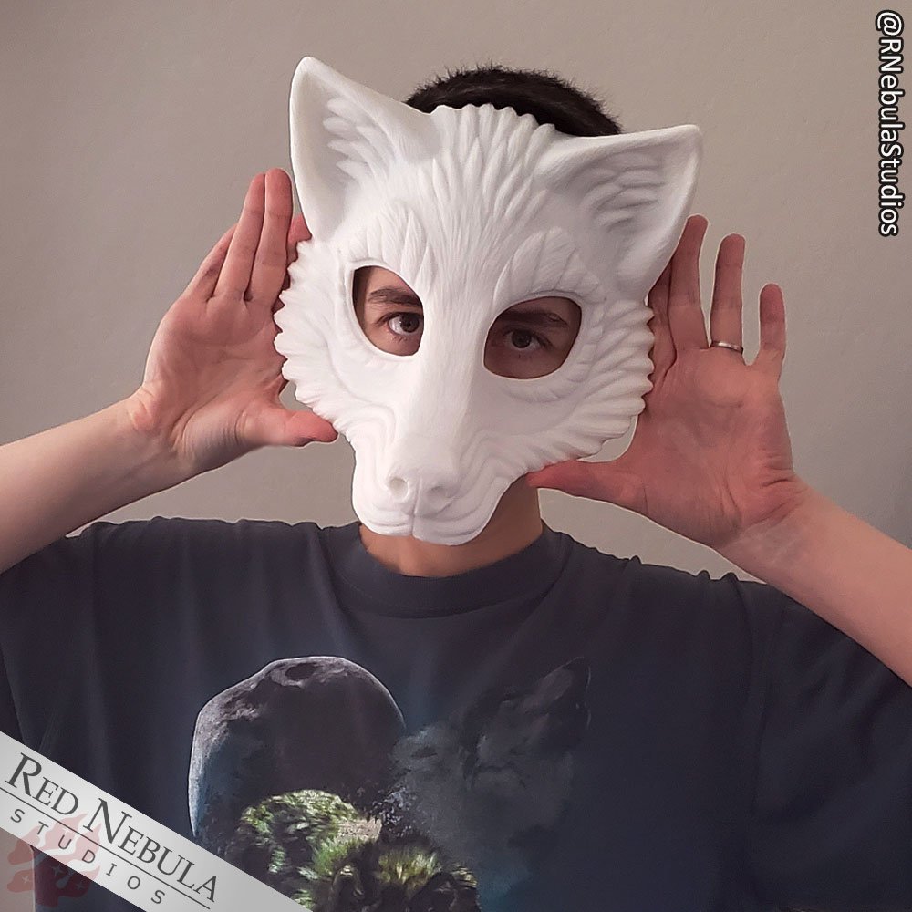 A woman (the artist) holding a white blank wolf mask up to her face.