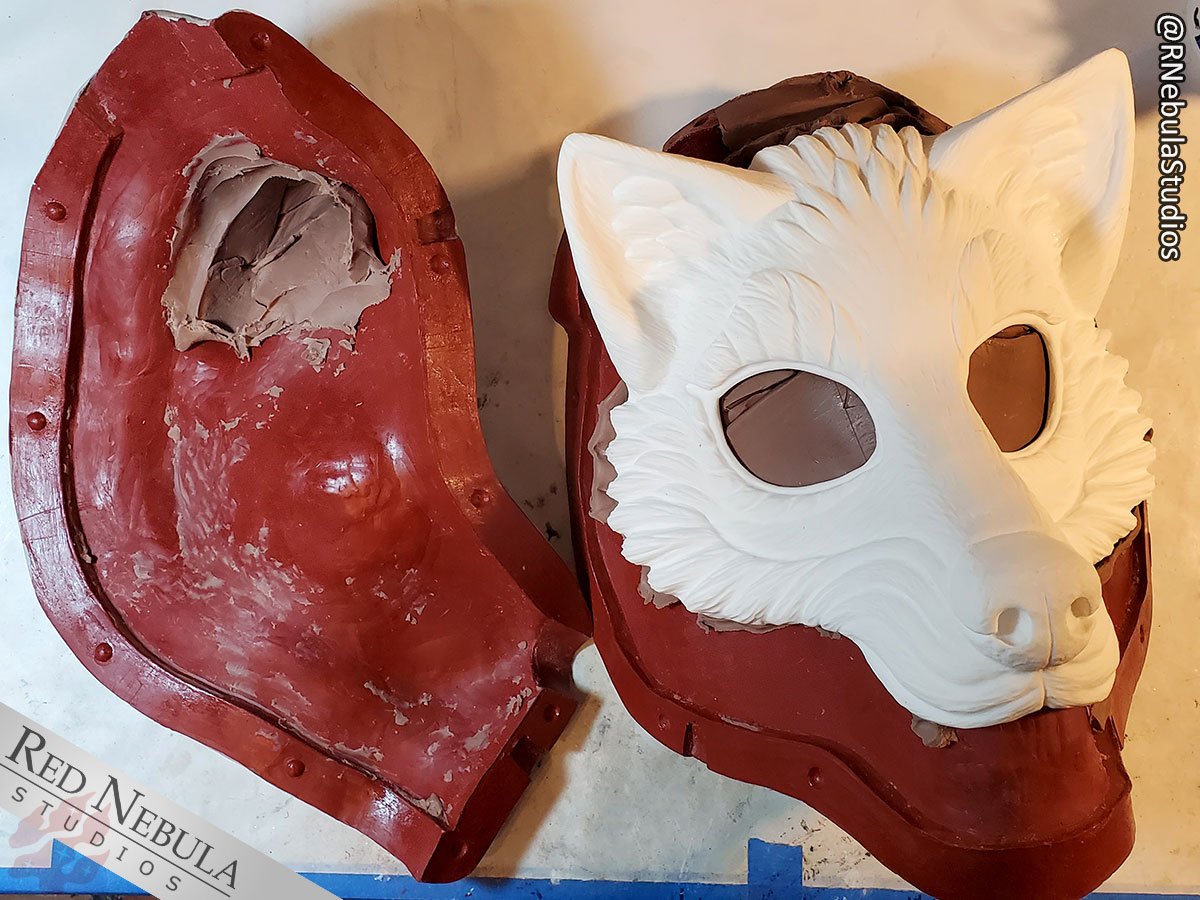 A blank white resin wolf mask in its partially completed mold.